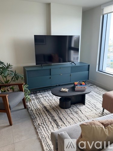 A living room with a flat screen TV on a cabinet.