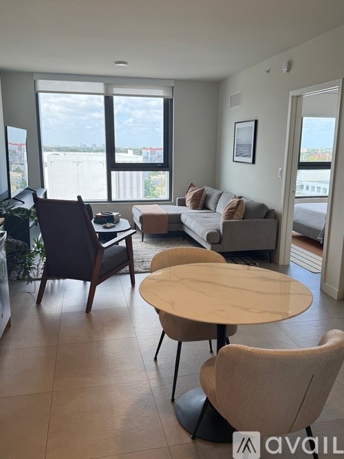 A living room with a couch, chairs, and a table.