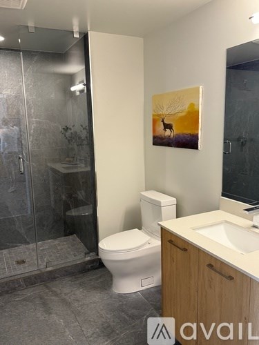 A bathroom with a toilet, sink, and a painting of a deer.