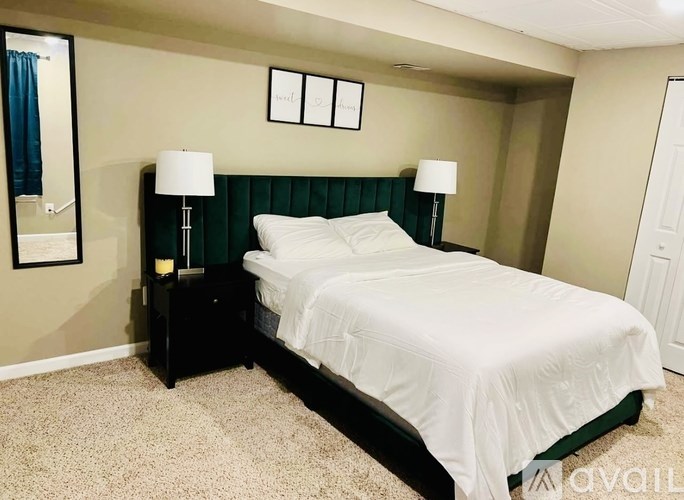 A bedroom with a bed, nightstands, and a mirror.