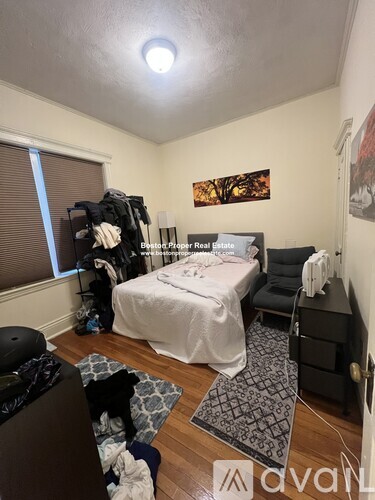 A bedroom with a bed, a chair, and a dog.