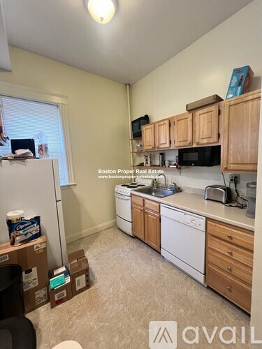 A kitchen with wooden cabinets and a white dishwasher.