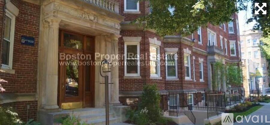 A red brick building with a wooden door and a window above it.
