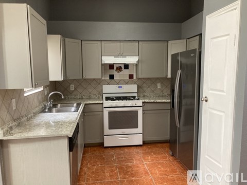 A kitchen with a white stove top oven and a white refrigerator.
