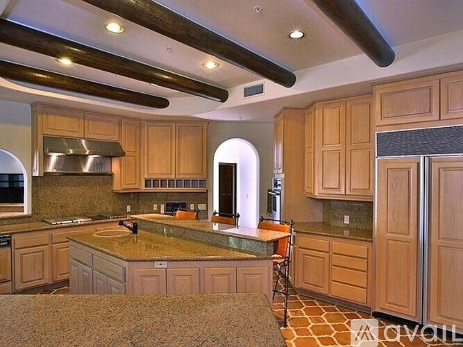 A kitchen with wooden cabinets and a granite countertop.