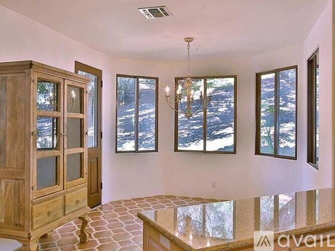 A room with a wooden cabinet and a chandelier.