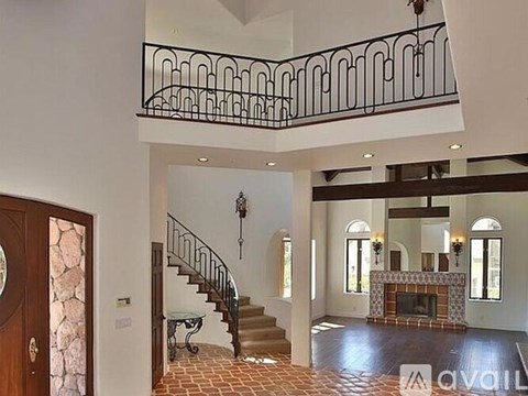 A large open living room with a staircase and a fireplace.