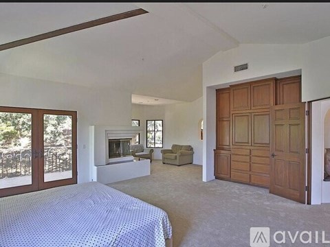 A bedroom with a bed, a couch, and a fireplace.
