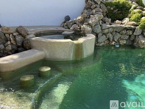 A small pool with a waterfall and rocks.