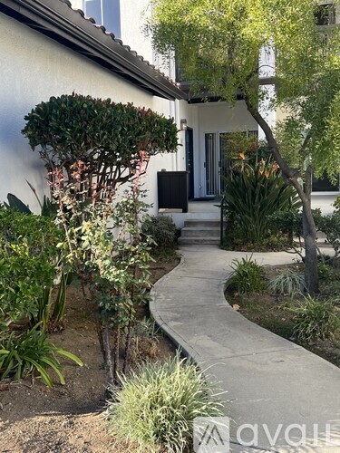A white house with a garden in front.