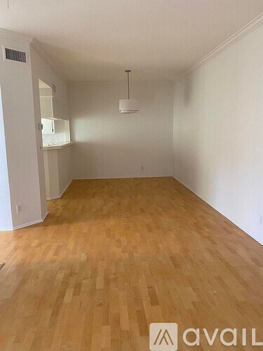 A room with wooden flooring and a hanging light fixture.
