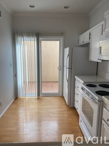 A kitchen with white cabinets and a stove top oven.