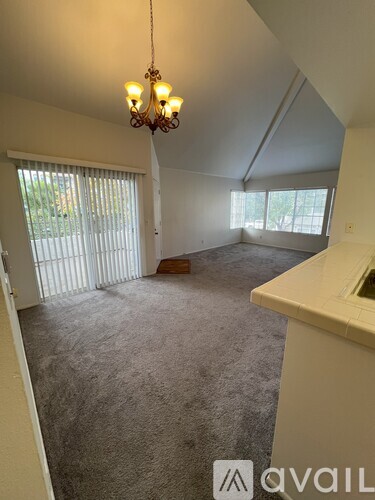 A room with a chandelier and carpeted floor.