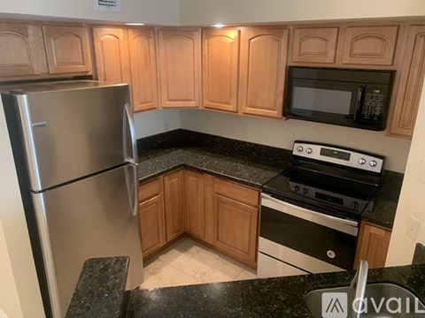 A kitchen with wooden cabinets and a black countertop.