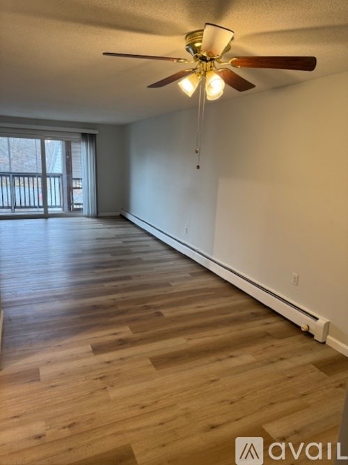 A room with wooden flooring and a ceiling fan.