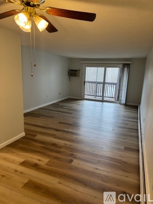 A room with wooden flooring and a ceiling fan.