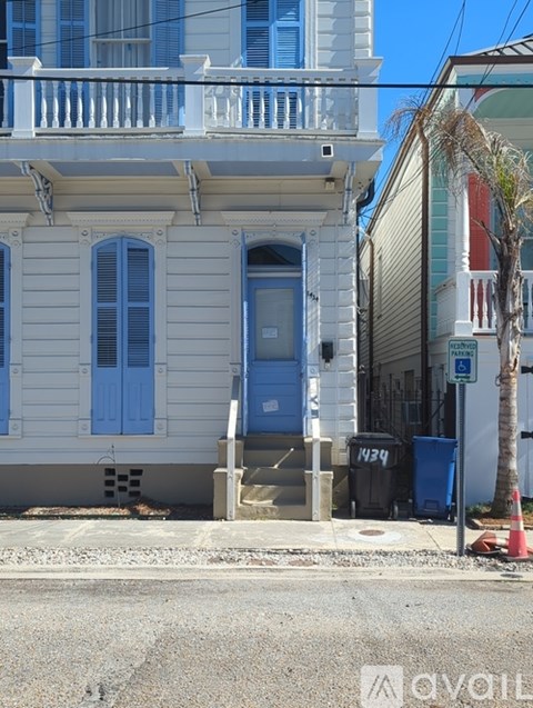 A white house with a blue door and a sign that says "No Parking".