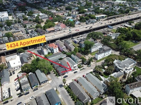 An aerial view of a city with a red arrow pointing to a specific building.