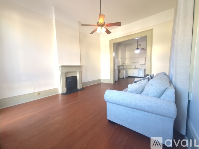 A living room with a blue couch and a fireplace.