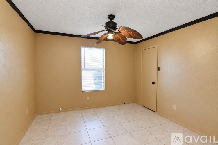 A room with a ceiling fan and a window.