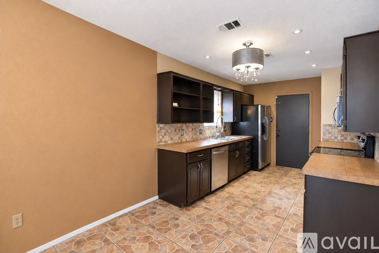 A kitchen with brown cabinets and a tiled floor.