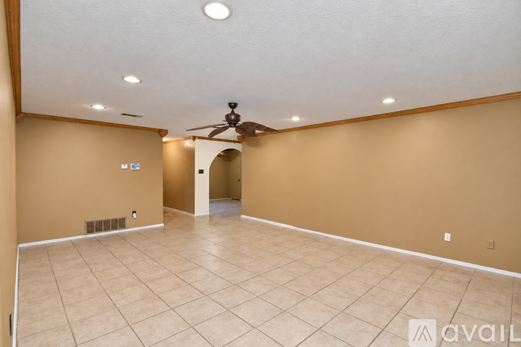 A spacious room with a ceiling fan and sliding glass doors.