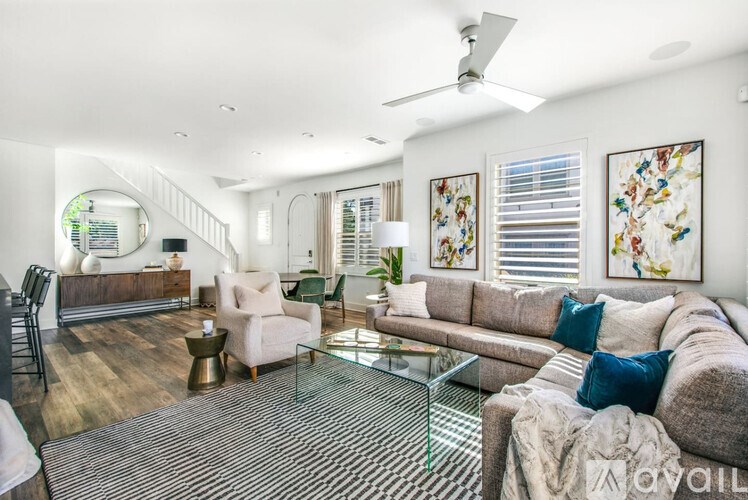 A living room with a grey sofa and a glass coffee table.