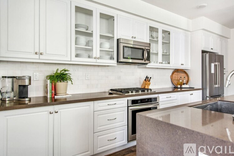 A kitchen with white cabinets and a granite countertop.