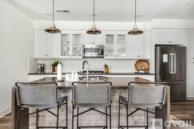 A kitchen with white cabinets and a black countertop.