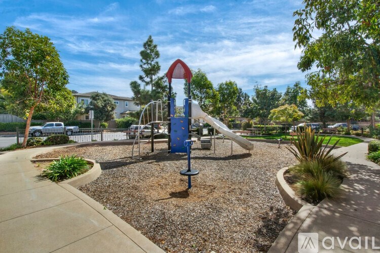 A playground with a blue slide and a red and white sign.