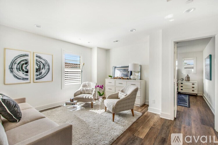 A living room with a couch, chair, and a painting on the wall.