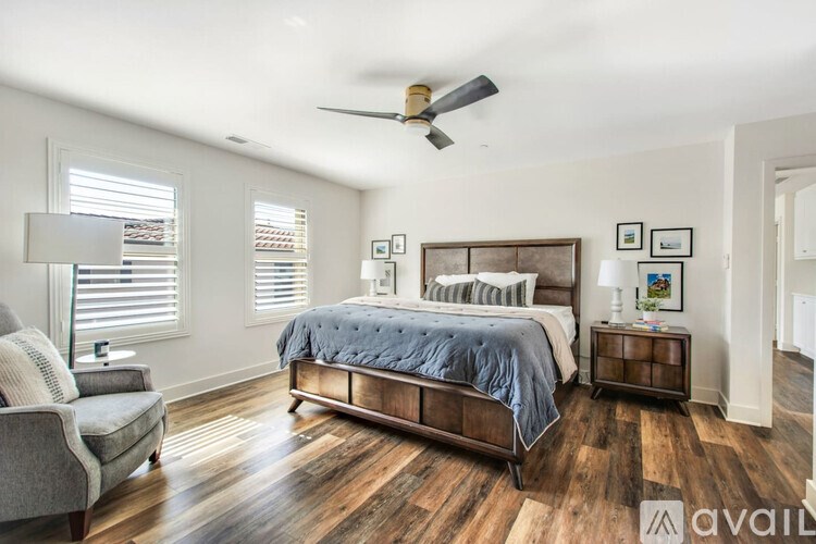 A bedroom with a bed, nightstand, and chair.