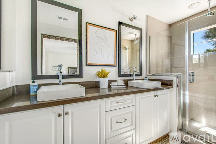 A bathroom with two sinks and a large mirror.