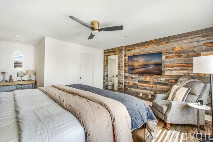 A bedroom with a large bed and a wooden wall.