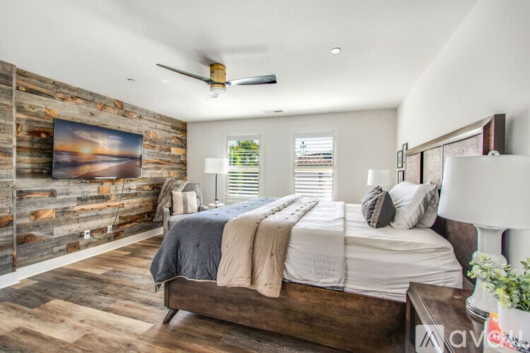 A bedroom with a wooden headboard and a large bed.
