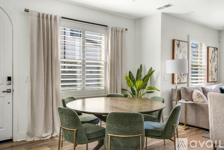 A dining room with a round table surrounded by chairs.