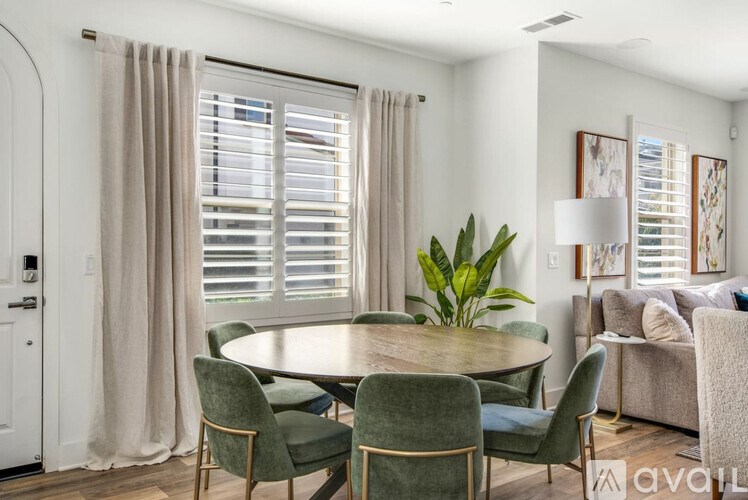 A dining room with a round table surrounded by chairs.