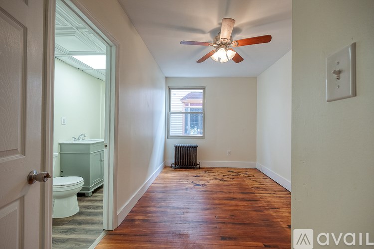 A room with a wood floor and a ceiling fan.