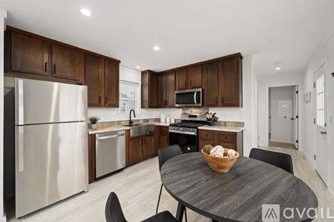 A modern kitchen with dark wood cabinets and stainless steel appliances.