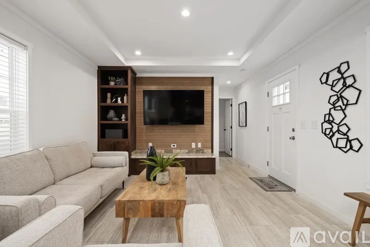 A living room with a wooden coffee table and a grey sofa.