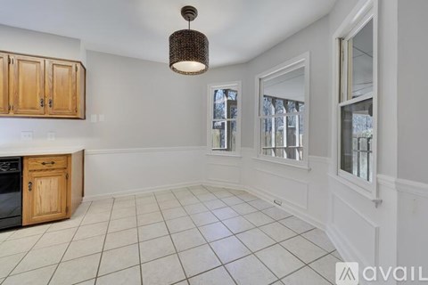 A kitchen with wooden cabinets and a tiled floor.