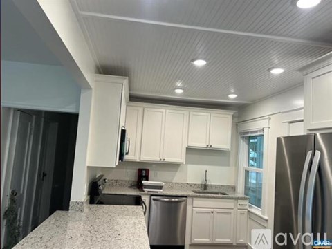 A kitchen with white cabinets and a granite countertop.