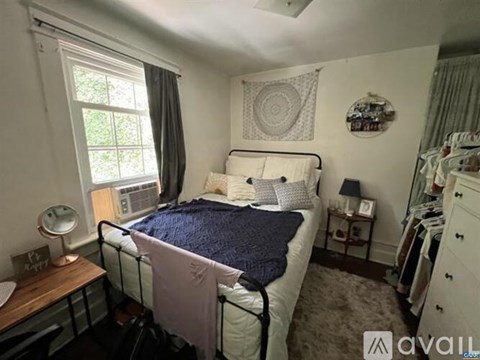 A bedroom with a bed, nightstand, and window.