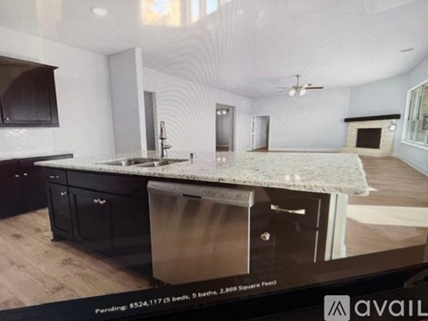 A modern kitchen with a large island and black cabinets.