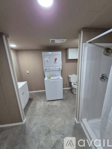 A small bathroom with a toilet, sink, and shower.