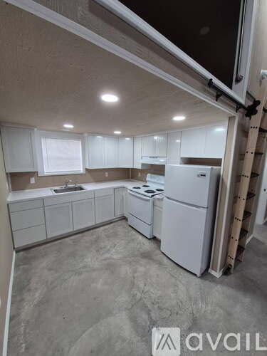 A kitchen with white appliances and cabinets.