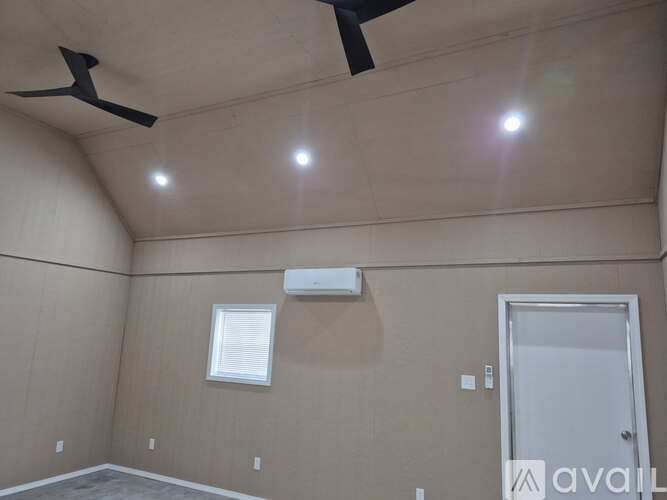 A room with a ceiling fan, window, and door.