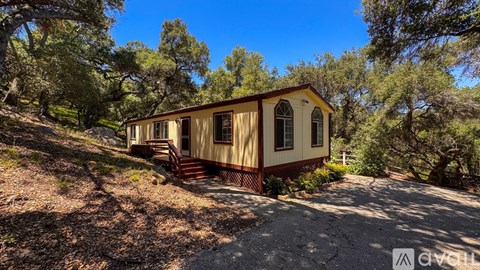 A wooden deck with a red railing and a green roof.