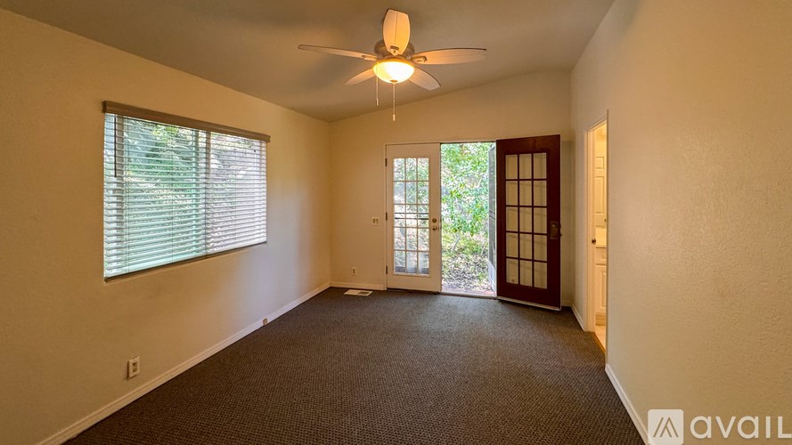 A room with a window and a carpeted floor.