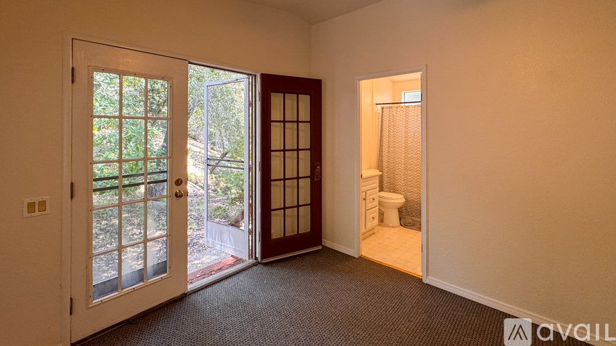 A room with a ceiling fan and two windows.